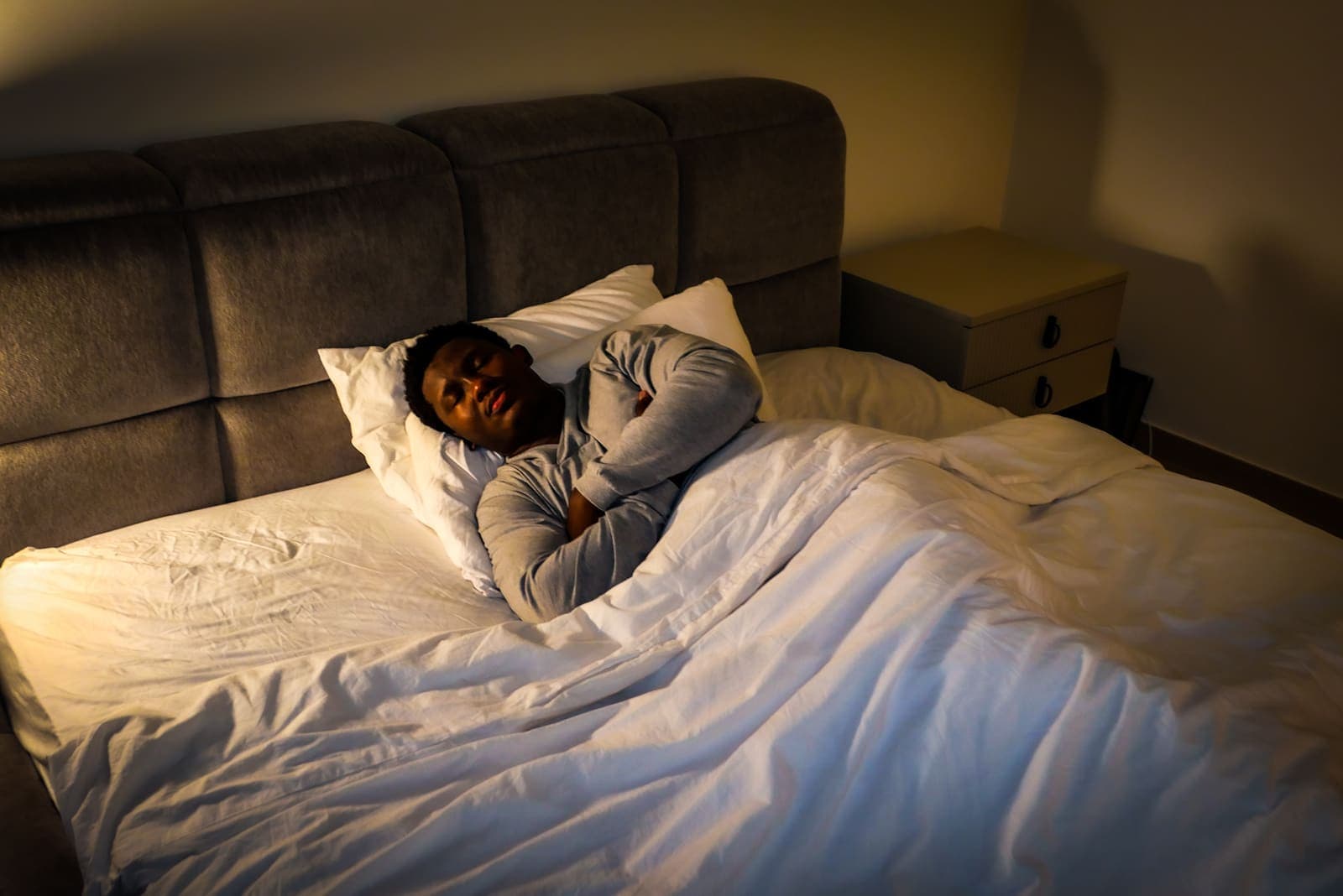 KojoForex asleep before the 02:00 GMT alarm, warm bedside lamp